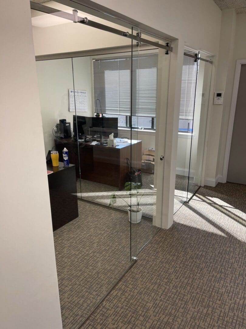 A room with glass walls and a desk.